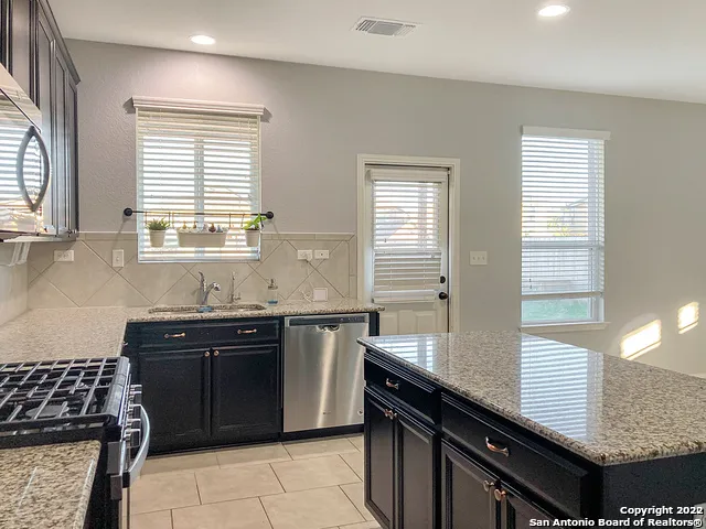 a kitchen with a sink stove top oven and cabinets