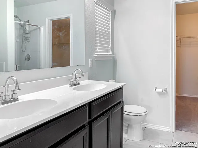 a bathroom with a sink a toilet shower and a mirror