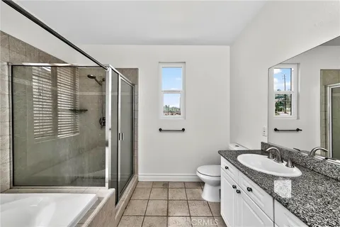 a bathroom with a granite countertop sink a toilet and shower