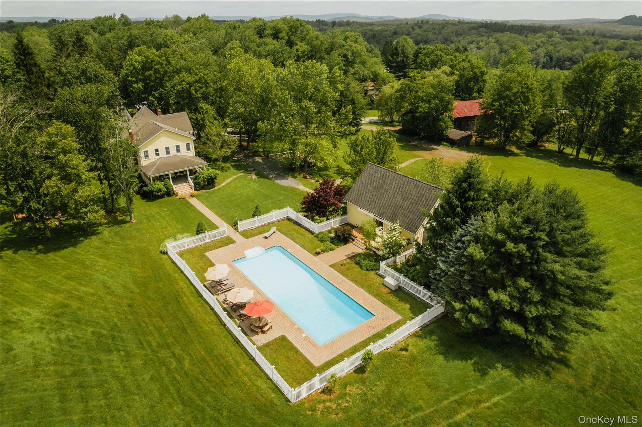 an aerial view of residential house with outdoor space and trees all around