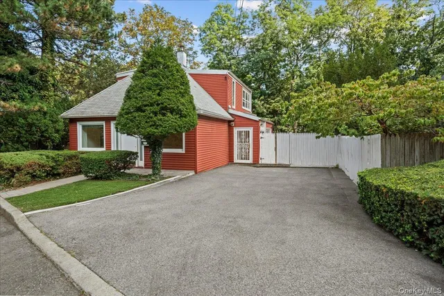 a front view of a house with a yard and tree