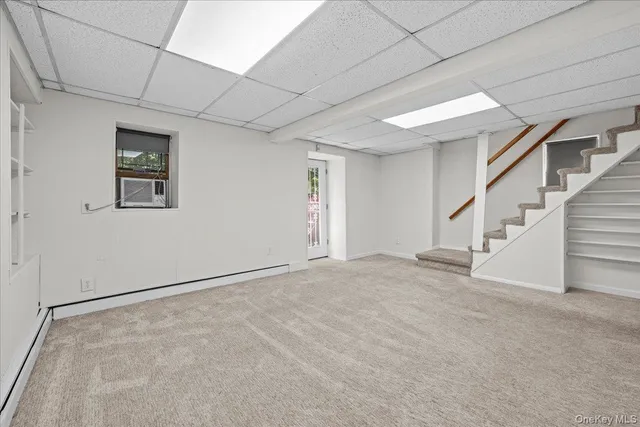 a view of an empty room with stairs and a window