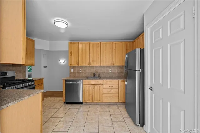 a kitchen with stainless steel appliances granite countertop a refrigerator and a stove top oven