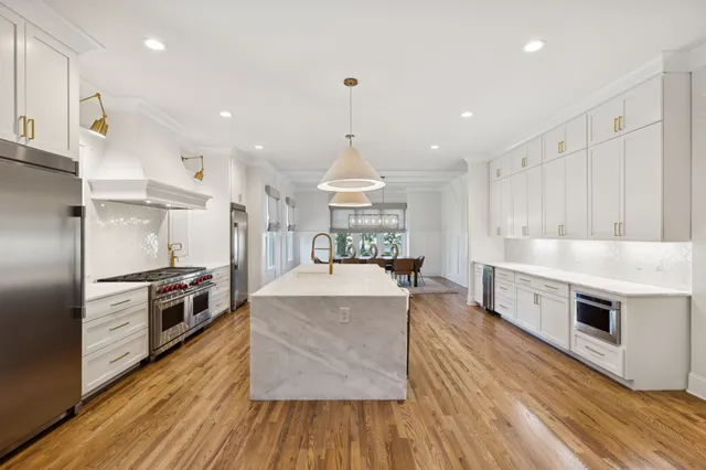 a kitchen with kitchen island a dining table and chairs