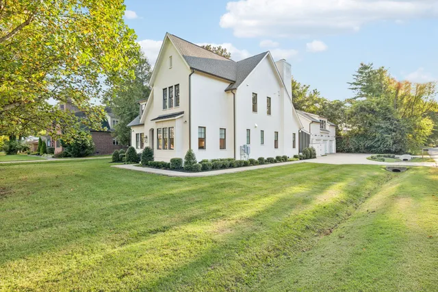 a front view of a house with a yard and trees