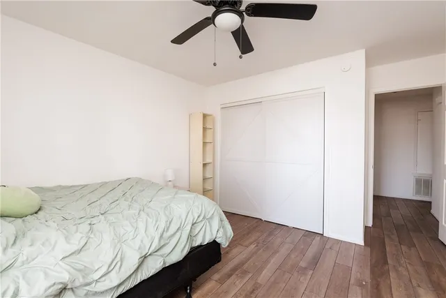 a bedroom with a bed and wooden floor