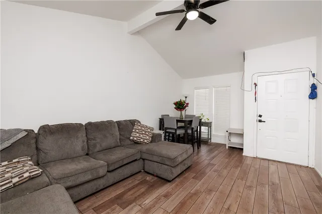 a living room with furniture and a wooden floor