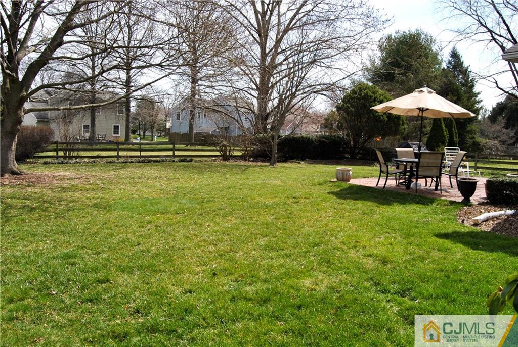 18 Krebs Road Plainsboro, NJ 08536 - Photo 22 of 24 a backyard of a house with table and chairs under an umbrella