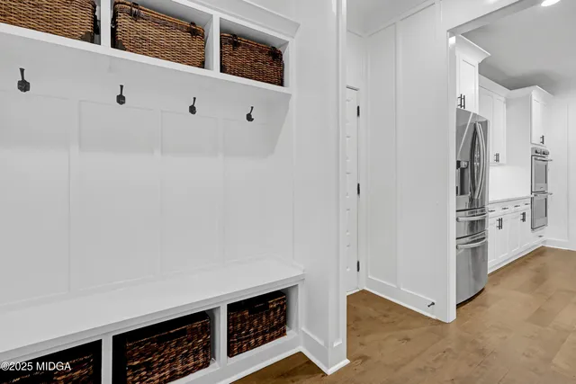 a bedroom with a bed a chandelier and a mirror on the dresser