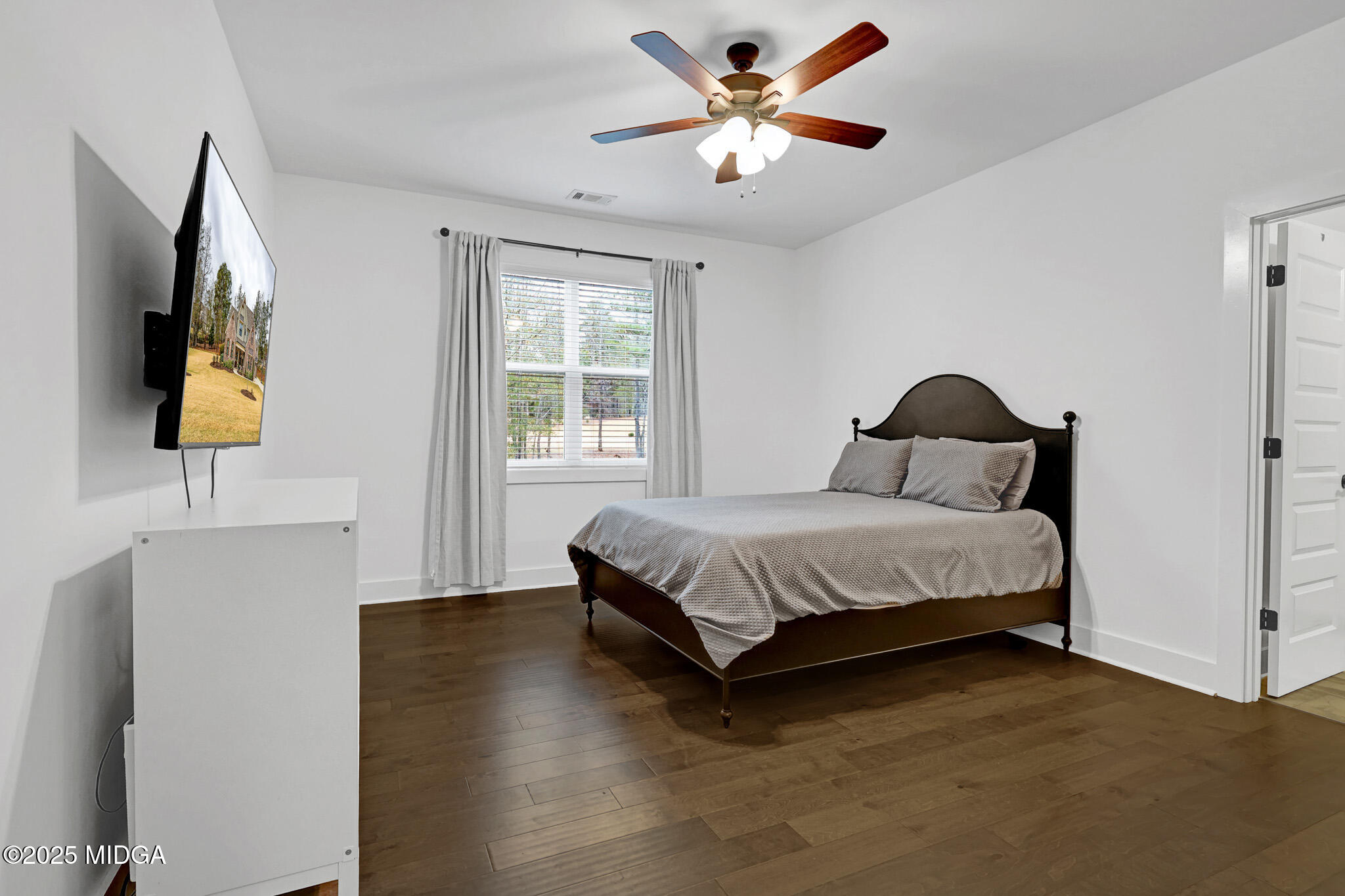 205 Chastain Drive Forsyth, GA 31029 - Photo 53 of 72 a bedroom with a bed and a flat tv screen on dresser