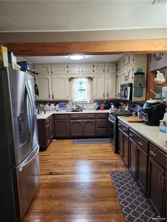 a large kitchen with stainless steel appliances and a refrigerator