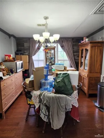a living room with furniture kitchen view and a chandelier