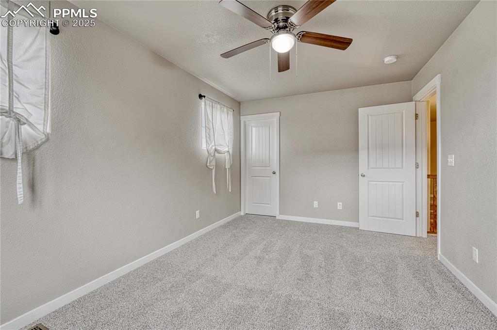 11298 Scenic Brush Drive Peyton, CO 80831 - Photo 32 of 50 an empty room with chandelier fan and windows