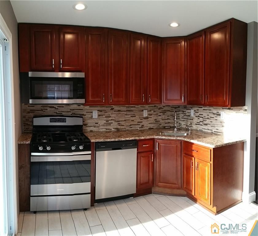 10 Richmond Road Edison, NJ 08817 - Photo 6 of 12 a kitchen with granite countertop wooden cabinets and stainless steel appliances