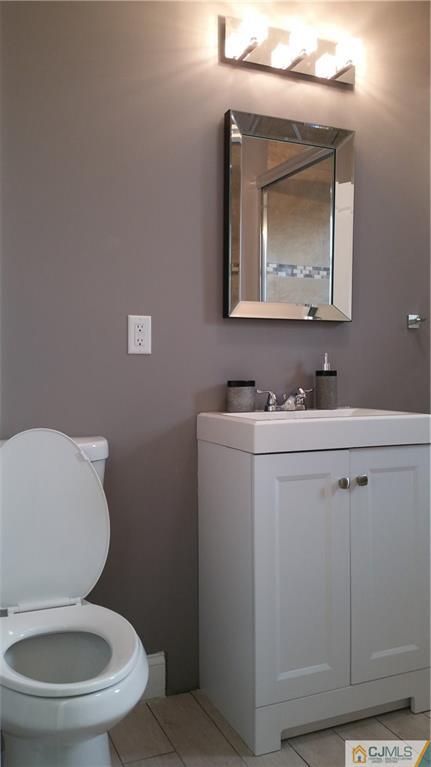 10 Richmond Road Edison, NJ 08817 - Photo 9 of 12 a bathroom with a toilet sink vanity and mirror