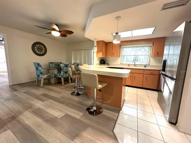 a kitchen with stainless steel appliances granite countertop a stove a sink a dining table and chairs