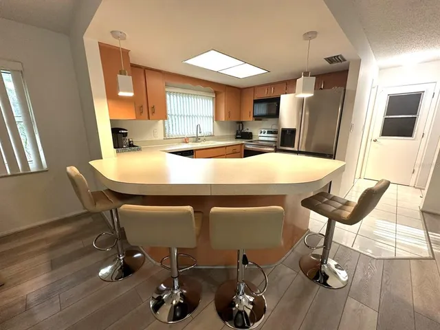 a kitchen with a table chairs refrigerator and window
