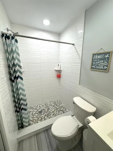 a white toilet sitting next to a shower curtain