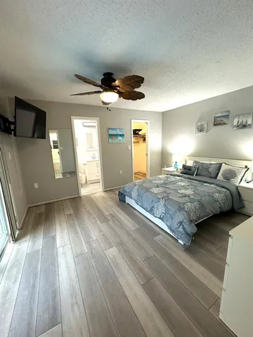 a spacious bedroom with a bed and wooden floor