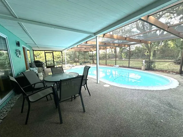 a dining room with furniture and a floor to ceiling window