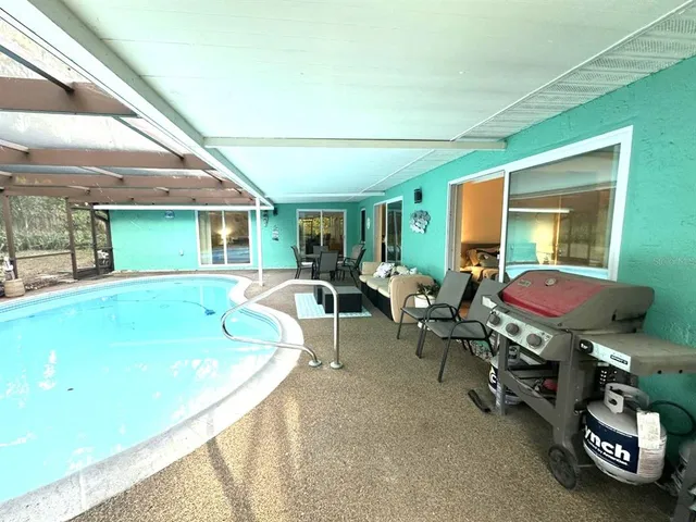 a living room with furniture a flat screen tv and a large window