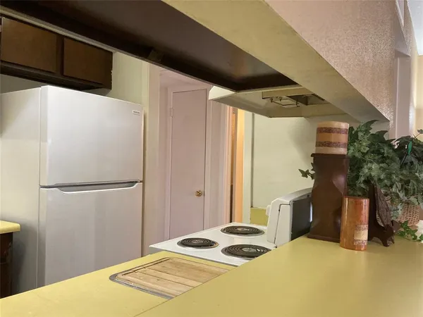 a bedroom with a bed and a refrigerator