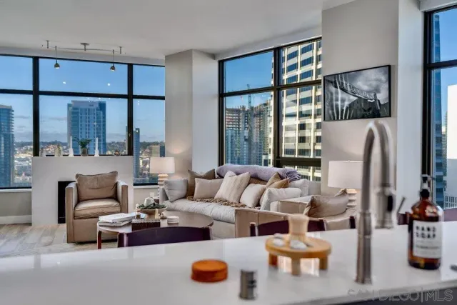 a kitchen with stainless steel appliances kitchen island granite countertop a refrigerator a stove a sink a dining table and chairs with wooden floor