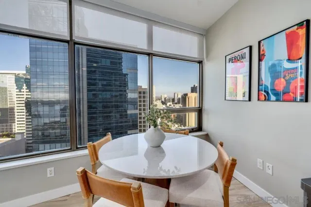 a living room with furniture large window and wooden floor