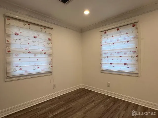 a view of a small space with wooden floor and a window