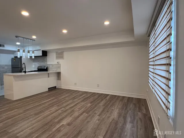 a view of a kitchen with a sink and dishwasher a refrigerator with wooden floor