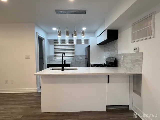a view of a kitchen with stainless steel appliances granite countertop a sink and a stove