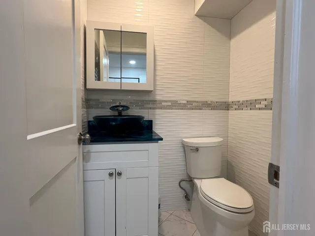 a bathroom with a toilet a sink and mirror