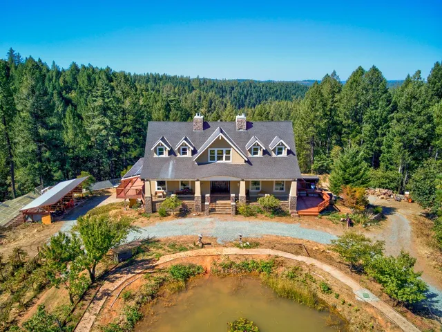 an aerial view of a house with a garden and lake view