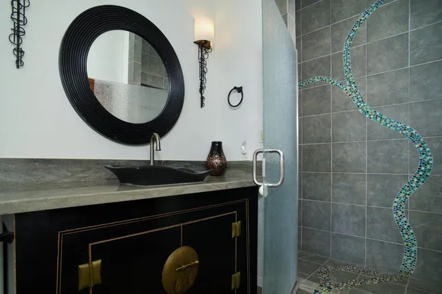 a bathroom with a granite countertop sink a mirror a bathtub and shower