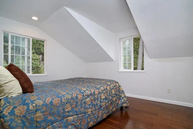 a balcony with wooden floor and trees in the background