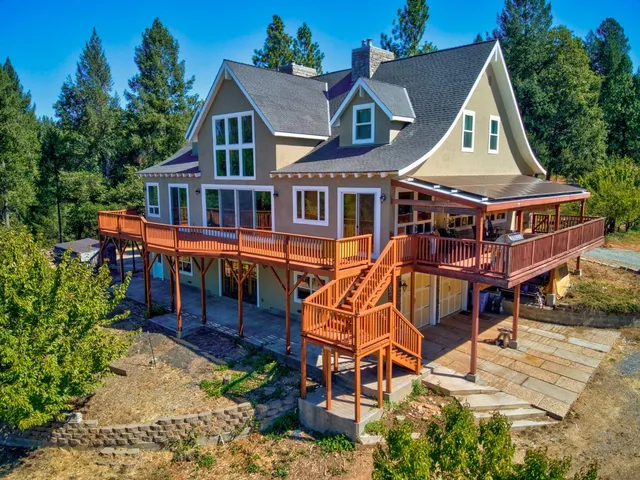 an aerial view of a house with lake view and a floor to ceiling window