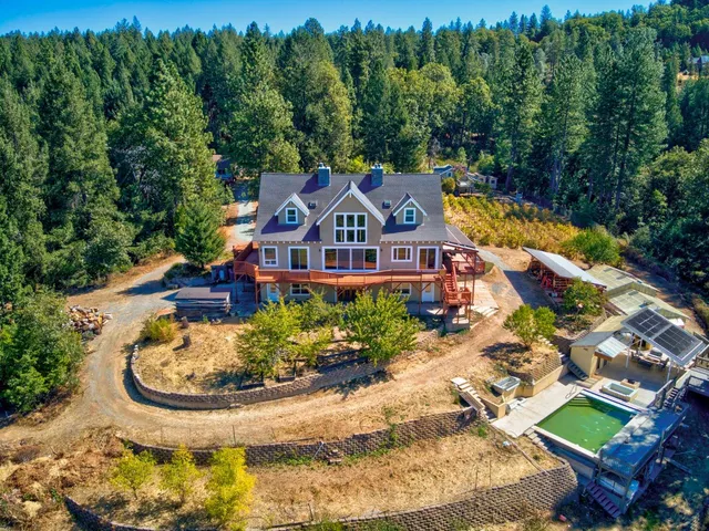 an aerial view of a house with garden space and outdoor seating