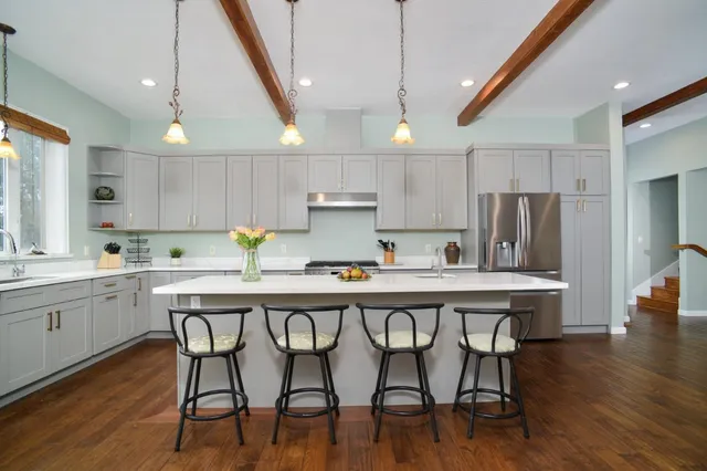 a kitchen with stainless steel appliances granite countertop a white cabinets and wooden floors
