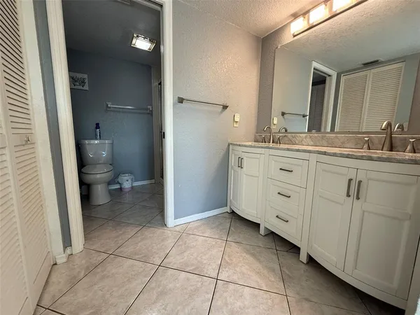 a white toilet sitting next to a bathroom sink and a shower