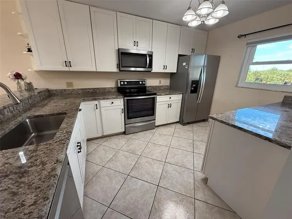 a kitchen with a sink cabinets and window