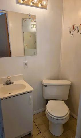 a bathroom with a toilet a sink and mirror
