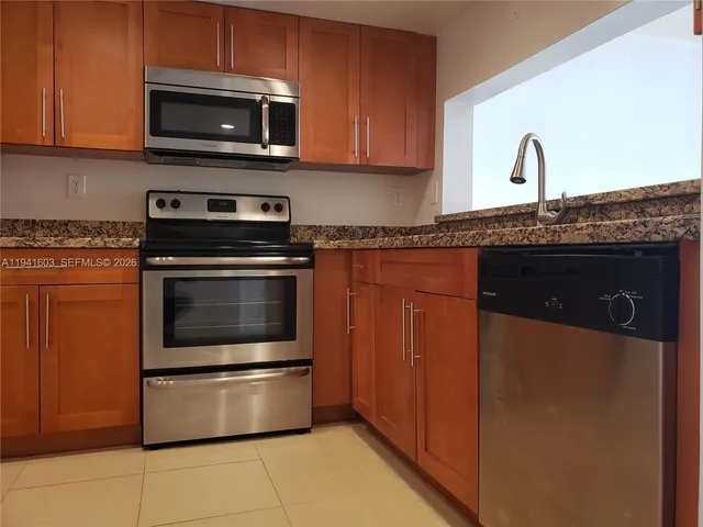 a kitchen with granite countertop a stove and a microwave