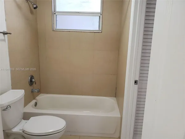 a white bath tub sitting next to a white toilet
