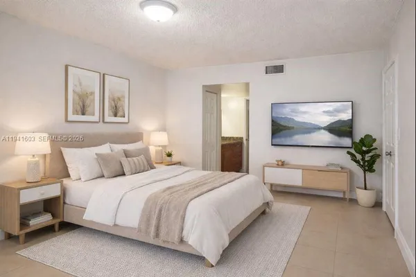 a bedroom with a large bed and a flat screen tv