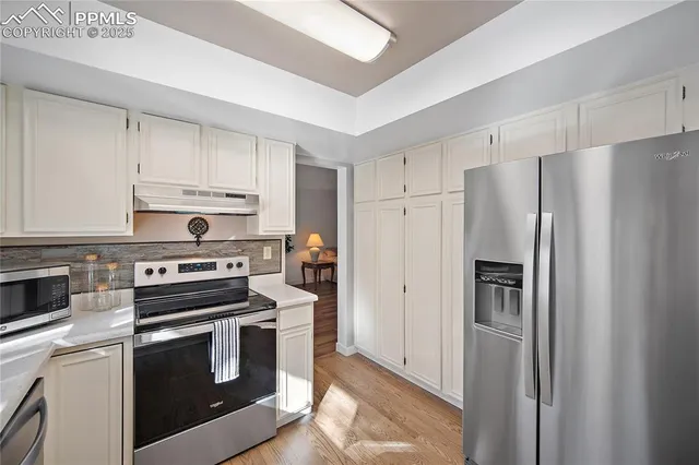 a kitchen with cabinets stainless steel appliances and a counter space