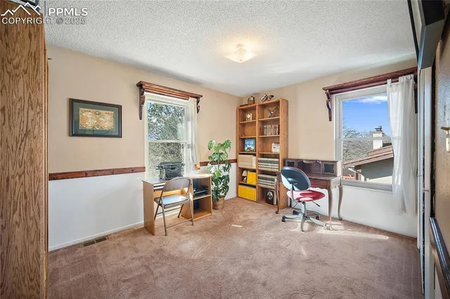 a view of a workspace with furniture and a window