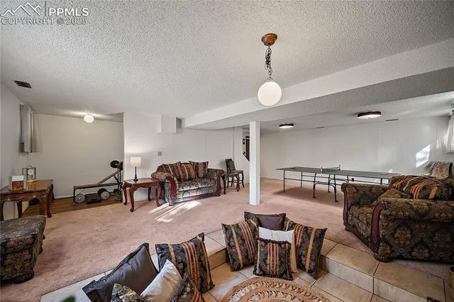 a living room with furniture kitchen view and a chandelier