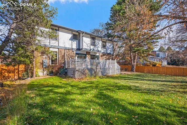 a view of a house with a big yard and large trees