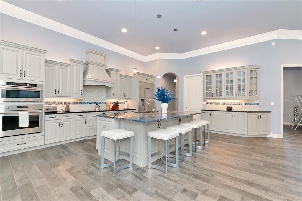 28154 Gopher Hill Road Myakka City, FL 34251 - Photo 28 of 100 a kitchen with stainless steel appliances kitchen island granite countertop a stove a sink a dining table and chairs