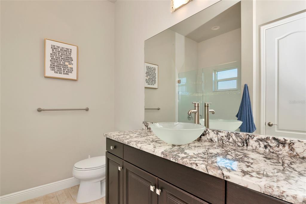 28154 Gopher Hill Road Myakka City, FL 34251 - Photo 72 of 100 a bathroom with a granite countertop sink and a mirror with toilet
